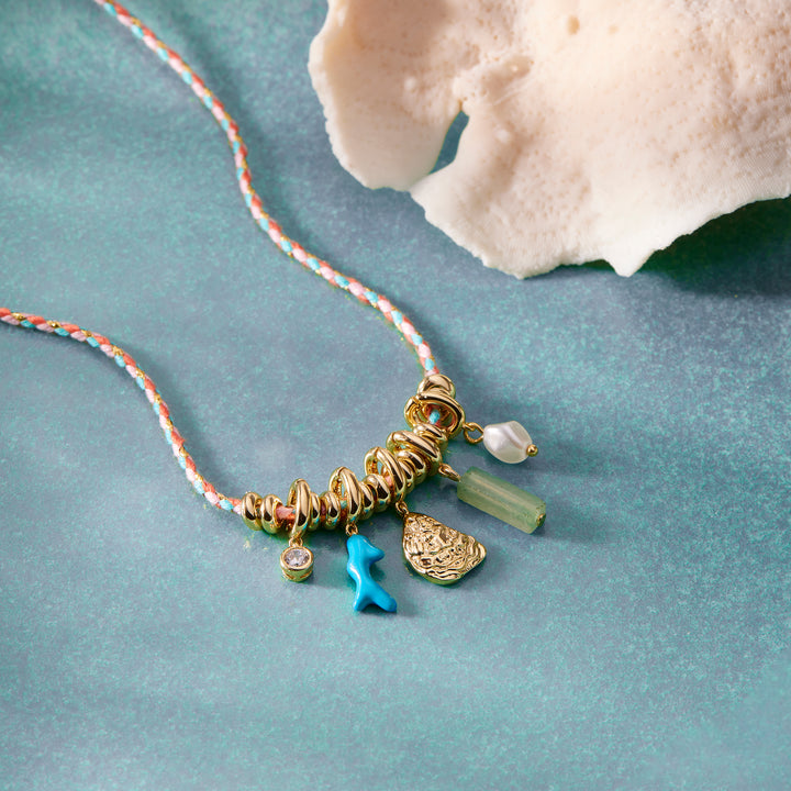 Necklace with charms on a textured blue surface