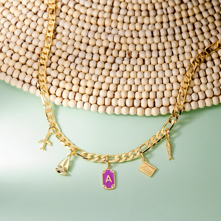 Gold necklace with charms on a textured surface