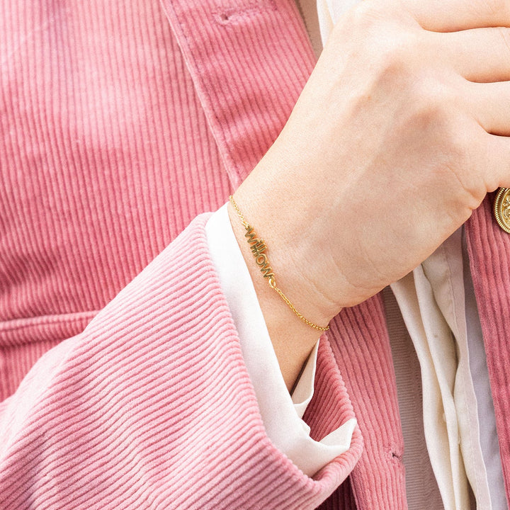 Woman wearing a pink corduroy jacket with gold buttons outdoors.