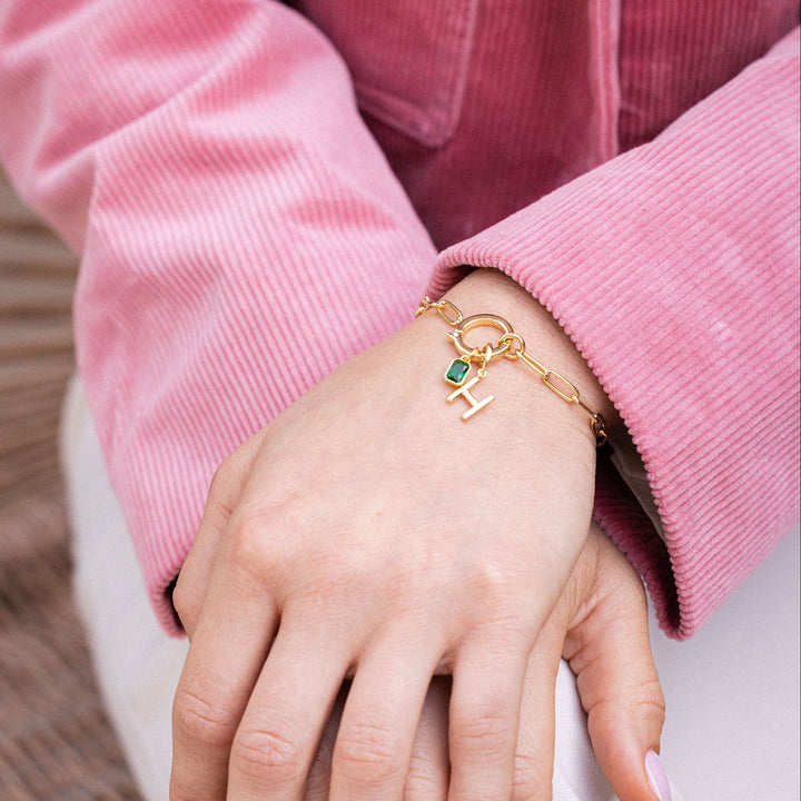 Close-up of hands with a gold bracelet and pink jacket