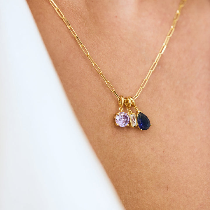 Gold necklace with three heart-shaped gemstones on a person&